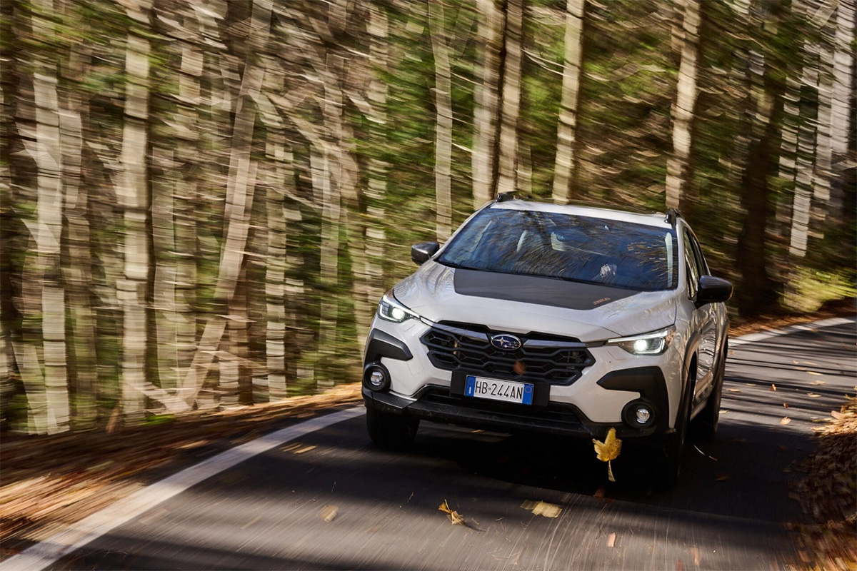 Subaru Crosstrek 4Wild blanche prenant un virage dans une route forestière