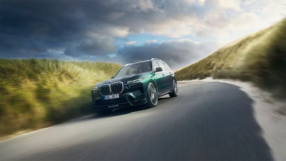 Le SUV BMW Alpina XB7 roulant à vive allure sur une route côtière sinueuse