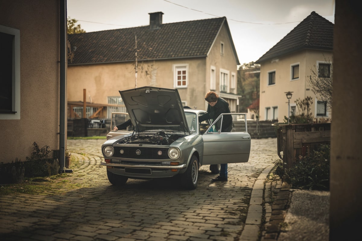 Borne de recharge électrique gratuite illuminée la nuit dans un petit village français